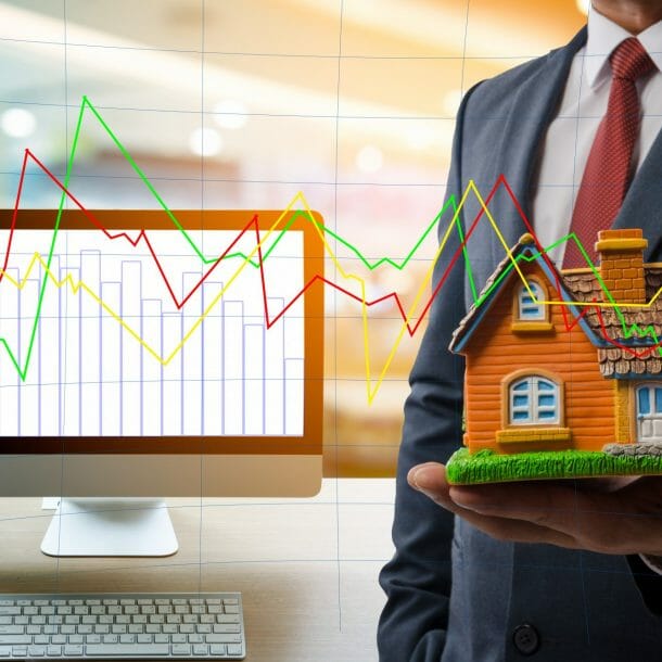 Stats and man holding model of house